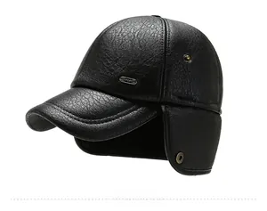 Detail of black winter baseball cap with ear flaps and metal sport emblem on PU leather