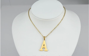 Detail of 18k gold plated stainless steel letter A necklace with diamonds on a neck model