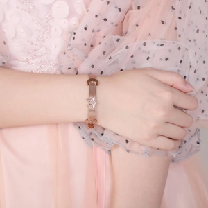 Adjustable rose gold moon and star stainless steel mesh bracelet on female wrist