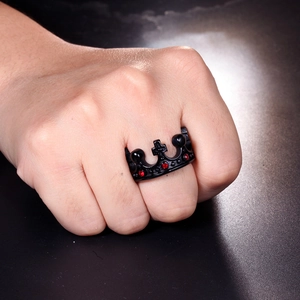 Close-up of a black crown ring featuring a red gemstone on a model hand with macro focus