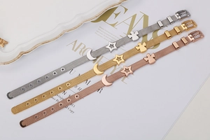 Dettaglio di braccialetti a maglia regolabili con ciondoli a forma di luna e stella in tre colori