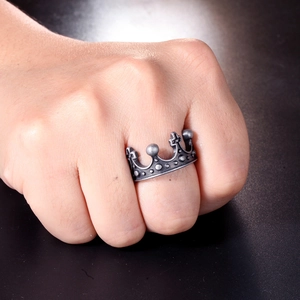 Macro shot of vintage crown ring with cross pattern in silver steel on male hand
