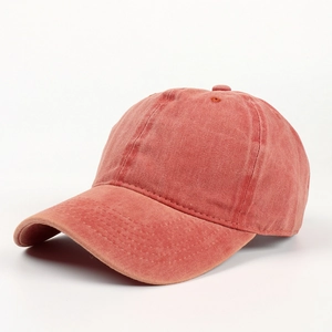 Detail of washed cotton baseball cap fabric texture and ventilation holes in brick red