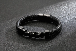 Close-up of men's braided leather bracelet with black metal twist and magnetic clasp