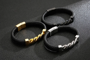 Detailed view of woven leather bracelets with twisted metal ornaments in gold, silver, and black