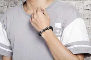 Men's black braided leather bracelet with vintage silver steel clasp on a male wrist