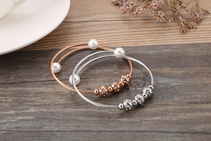 Close-up of twisted rope bracelets with white pearls and sparkling rhinestone beads