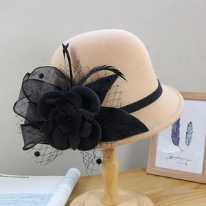 Detail of wool fedora hat featuring black floral net veil and feather embellishments