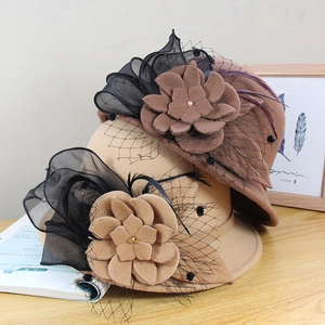 Detail of wool felt hats with fabric flowers, black mesh veil, and feather accents