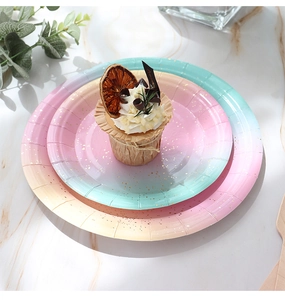 Macro shot of gradient pastel disposable paper plates with gold foil speckled pattern