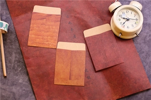 Flat lay of vintage kraft paper envelopes on a retro desk with a classic alarm clock