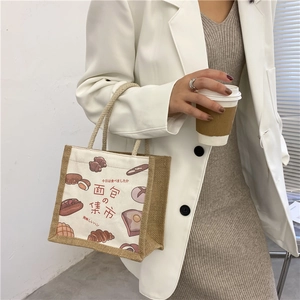 Detail of canvas and jute tote bag featuring bread illustration in a lifestyle scene