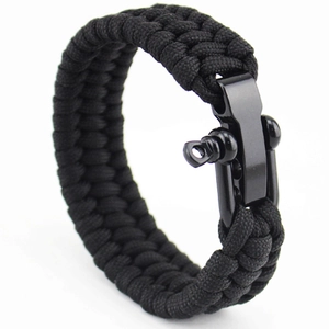 Detalle de pulsera de supervivencia de paracord negro con un robusto grillete de metal negro