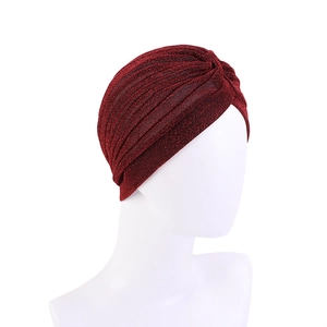 Detail of burgundy turban hat featuring pleated texture and shimmering metallic thread fabric