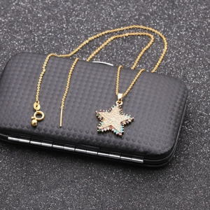 Macro shot of gold star pendant with micro-pave clear and multicolor zircon stones