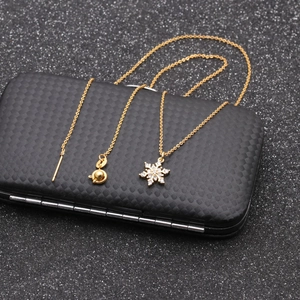 Close-up of gold snowflake pendant with micro-inlaid zircons and elegant chain details