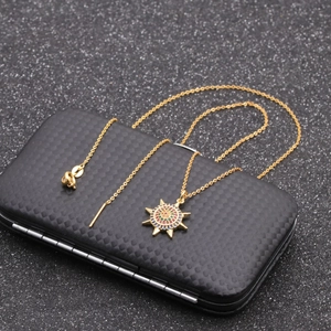 Golden sun pendant necklace with colored stones on textured black display box