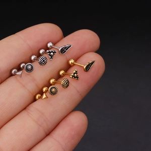 Surgical stainless steel stud earrings set in gold and silver plating on finger