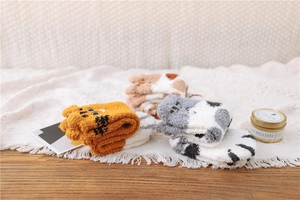 Detailed texture of thick coral fleece animal socks with cozy home background