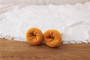 Detail of warm ginger coral fleece socks texture on a cozy wooden tabletop background