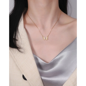 Élégant collier papillon en argent S925 doré porté avec une tenue professionnelle
