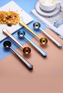 Five colored stainless steel measuring spoons with integrated bag clips on a modern background