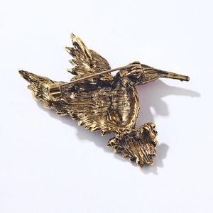 Detailed back view of hummingbird brooch showing golden metal texture and dual-use pin lock