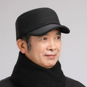 Close-up of black wool flat top winter hat with ear protection for elderly men