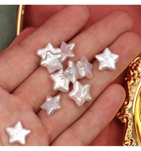 Detailed view of star-shaped natural freshwater pearls with iridescent luster held in hand