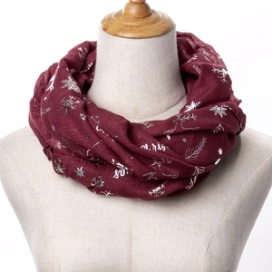 Detail of burgundy Christmas scarf featuring silver snowflake and reindeer foil prints