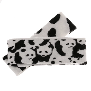Detail of soft knitted headband with black and white panda pattern for winter warmth