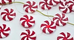 Macro detail of red and white swirl mint LED candy ornaments with gold wiring