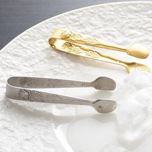 304 stainless steel sugar tongs with rose pattern in gold and silver finish on a plate