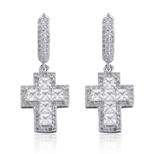 Vue détaillée des boucles d'oreilles créoles avec pendentifs croix et zircons incrustés