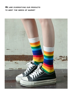 Detailed knit texture of rainbow striped crew socks worn with black canvas sneakers