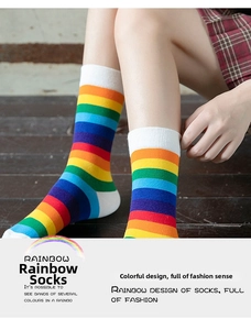 Detail of colorful rainbow striped knee high socks with white ribbed cuffs on a model