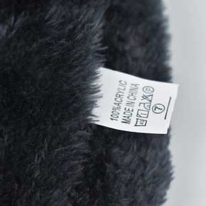 Close-up of internal wash label showing 100% acrylic material on black plush hat lining