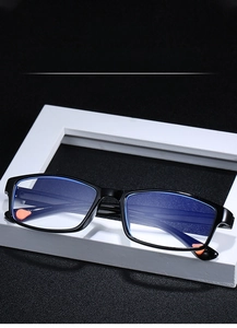 Detail view of blue light blocking reading glasses with black rectangular frame on white stand