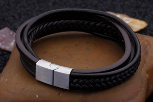 Close-up of multilayer braided leather bracelet with magnetic metal clasp on stone