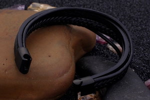 Detail of multi-layer black braided leather bracelet with stainless steel magnetic clasp