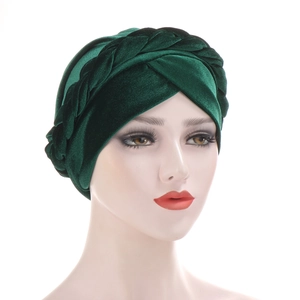 Dark green velvet turban hat featuring a stylish braided cross design on a mannequin