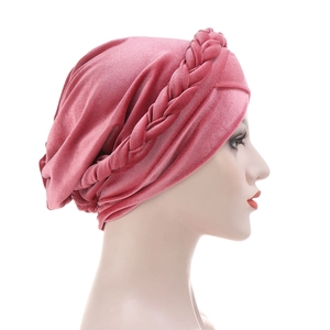 Detail of rose pink velvet turban hat with braided decoration on a mannequin