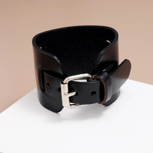 Detail of vintage black wide leather bracelet with adjustable silver buckle and metal eyelets