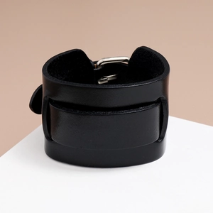Macro view of black vintage leather wristband texture with silver metal buckle detail