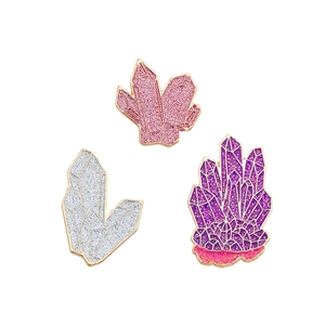 Tre spille a forma di cristallo colorato in rosa, argento e viola con smalto glitter