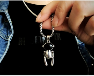 Dettaglio di una collana in acciaio al titanio argento con un ciondolo umanoide unico