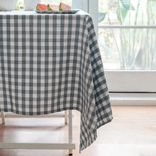 Close-up of grey and white checkered linen tablecloth with delicate fringe tassel detail