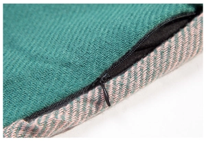 Detail of dark green twill and pink herringbone fabric with hidden zipper closure