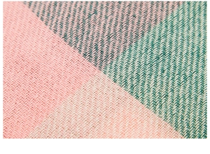 Macro shot of thick plaid knit fabric texture in pink green and beige for winter snood