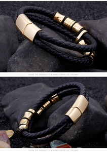 Detail of black braided leather bracelet with golden magnetic clasp on rock background